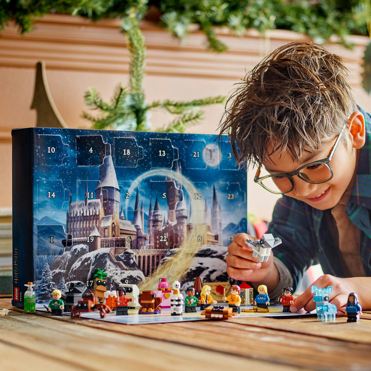 Child playing with LEGO figures in front of a Harry Potter-themed advent calendar.