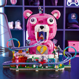 Pink teddy bear-shaped toy with a track and small figures on a dark surface.