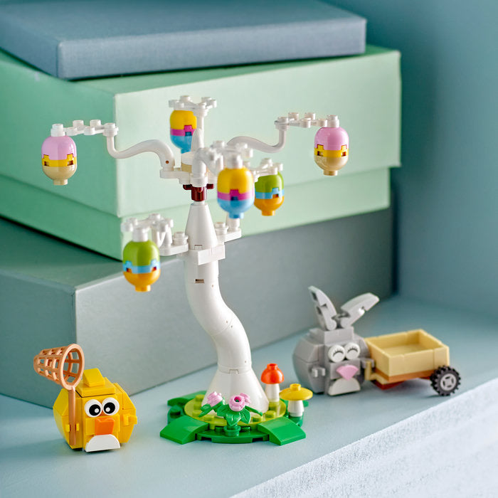 LEGO set with a tree, birds, and animals on a light blue surface.
