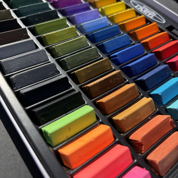 Set of colorful pastel crayons in a metal holder