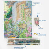 A diamond painting kit layout showing a completed multicolor garden and house scene on a pre-stretched canvas, with labeled accessories including a stylus, wax piece, craft tray, screws & hooks, and a pack of diamond dotz. The image is not a person-in-environment lifestyle shot and functions as a product explainer layout, so Product/Packaging is the best fit.