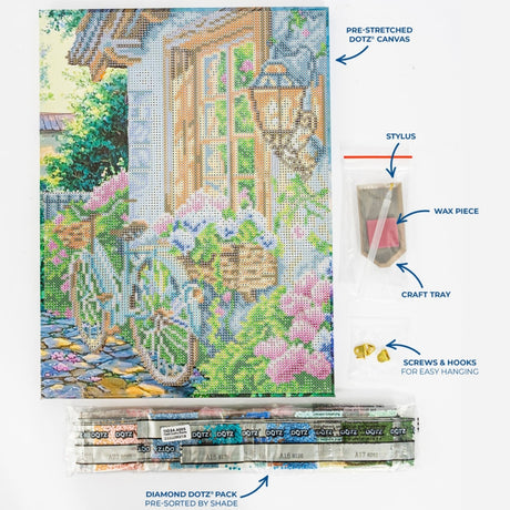 A diamond painting kit layout showing a completed multicolor garden and house scene on a pre-stretched canvas, with labeled accessories including a stylus, wax piece, craft tray, screws & hooks, and a pack of diamond dotz. The image is not a person-in-environment lifestyle shot and functions as a product explainer layout, so Product/Packaging is the best fit.