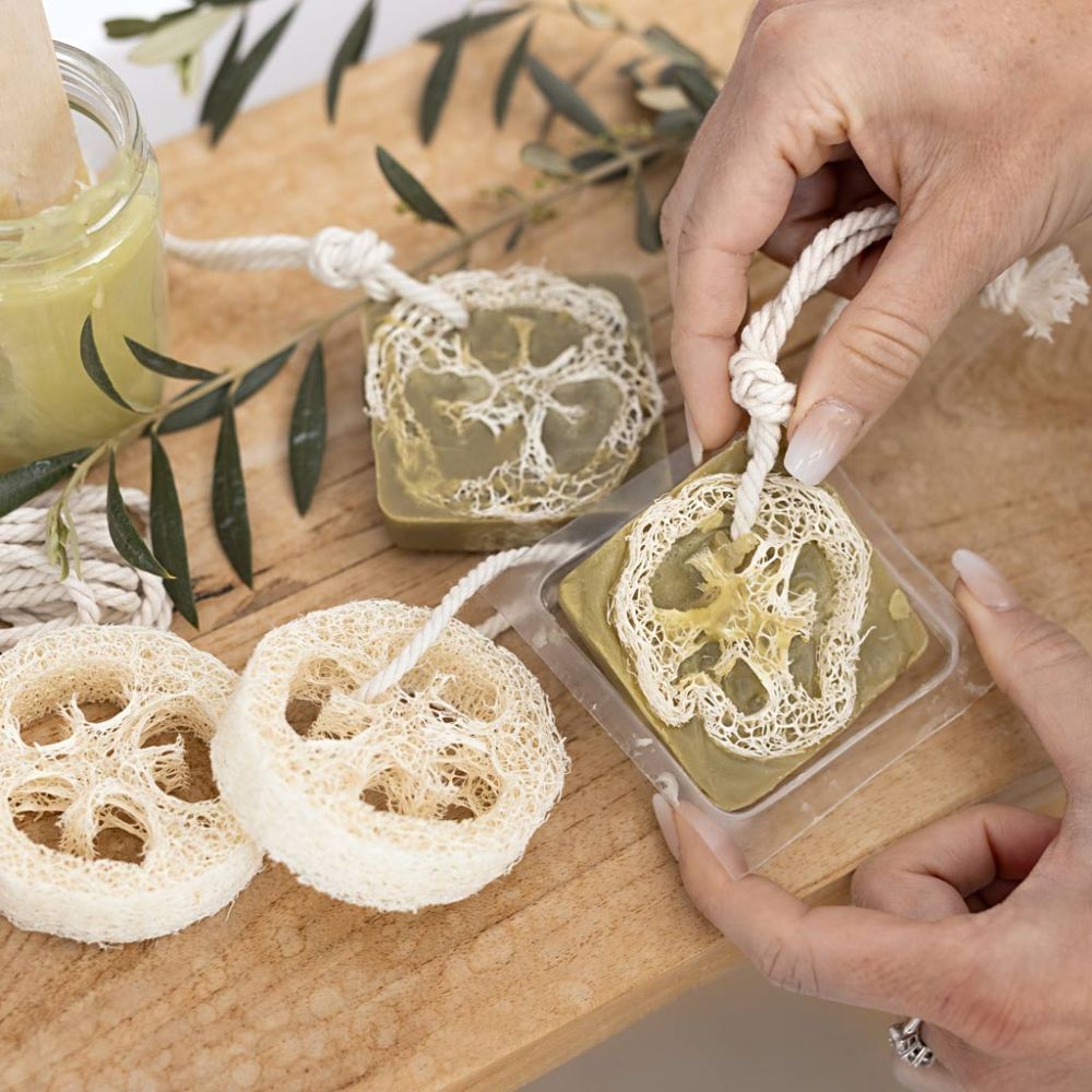 Hands holding a loofah soap with a wooden background