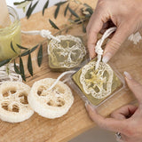 Hands holding a loofah soap with a wooden background