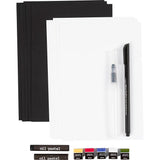 Art supply set with black paper, white paper, oil pastel sticks, and a pen on a white background.