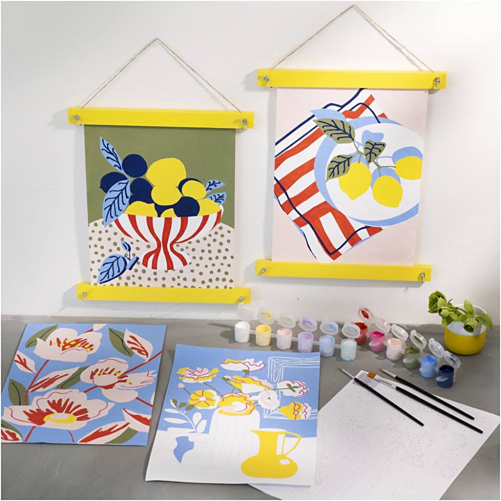 Colorful art prints on a gray surface with painting supplies.