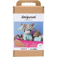 Amigurumi cow packaging with a crochet hook and yarn on a white background