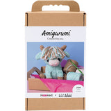 Amigurumi cow packaging with a crochet hook and yarn on a white background