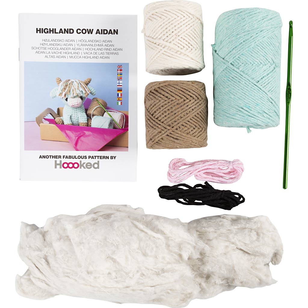 Yarn and crochet kit with yarn balls, a crochet hook, and a pattern book on a white background