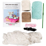 Yarn and crochet kit with yarn balls, a crochet hook, and a pattern book on a white background