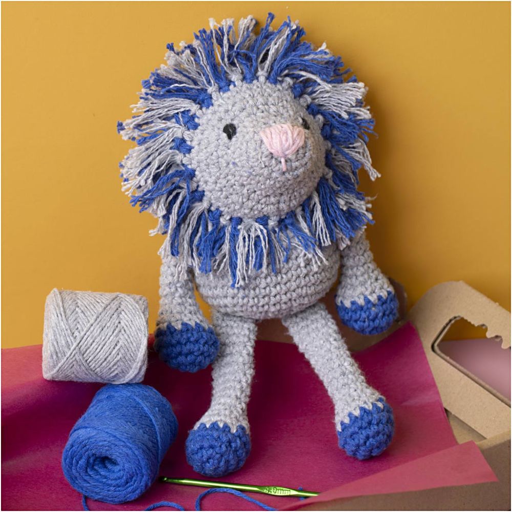 Crocheted lion toy with blue and gray colors on a yellow background