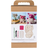 Knitting kit packaging with yarn, needles, and finished knitted toys on a white background