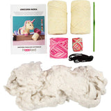 Knitting kit with yarn, needles, and pattern book on a white background