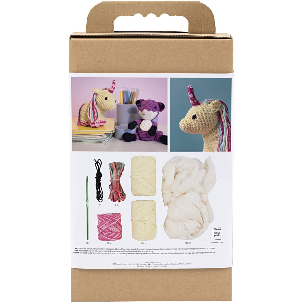 Crochet kit packaging with yarn, hooks, and finished unicorn toys on a white background