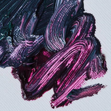 Close-up of swirling black and pink paint on a white background