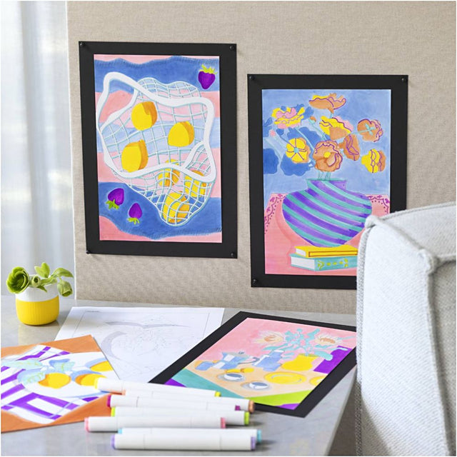 Colorful children's artwork on a wall with markers on a table below.