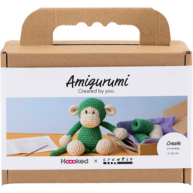 Amigurumi monkey kit packaging with cardboard box and green monkey toy inside