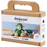 Box packaging for a green monkey amigurumi kit with 'Amigurumi Created by you' text.