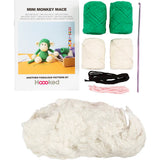Knitting kit with yarn, needles, and pattern book for creating a mini monkey mace by Hoooked.
