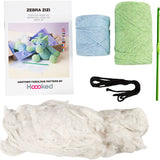 Knitting kit with yarn, needles, and pattern book displayed on a white background