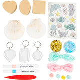 Collection of craft items including pom-poms, keychains, and stickers on a white background