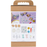 Cardboard box with craft materials and tools on a white background