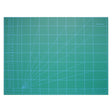 Green cutting mat with grid lines and measurements on a white background