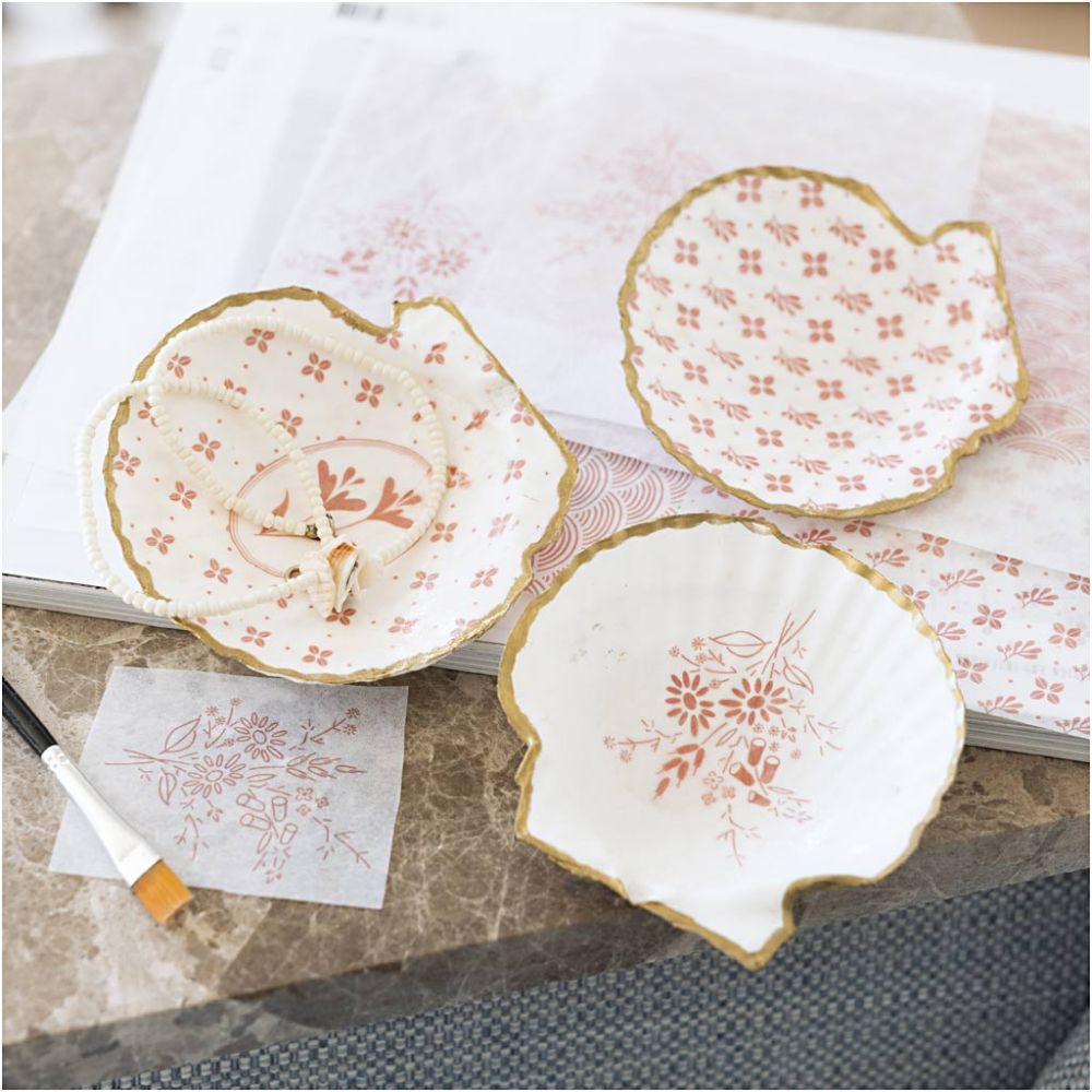 Decorative ceramic mussels with floral patterns on a marble surface