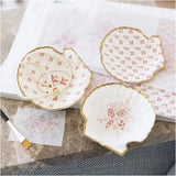 Decorative ceramic mussels with floral patterns on a marble surface