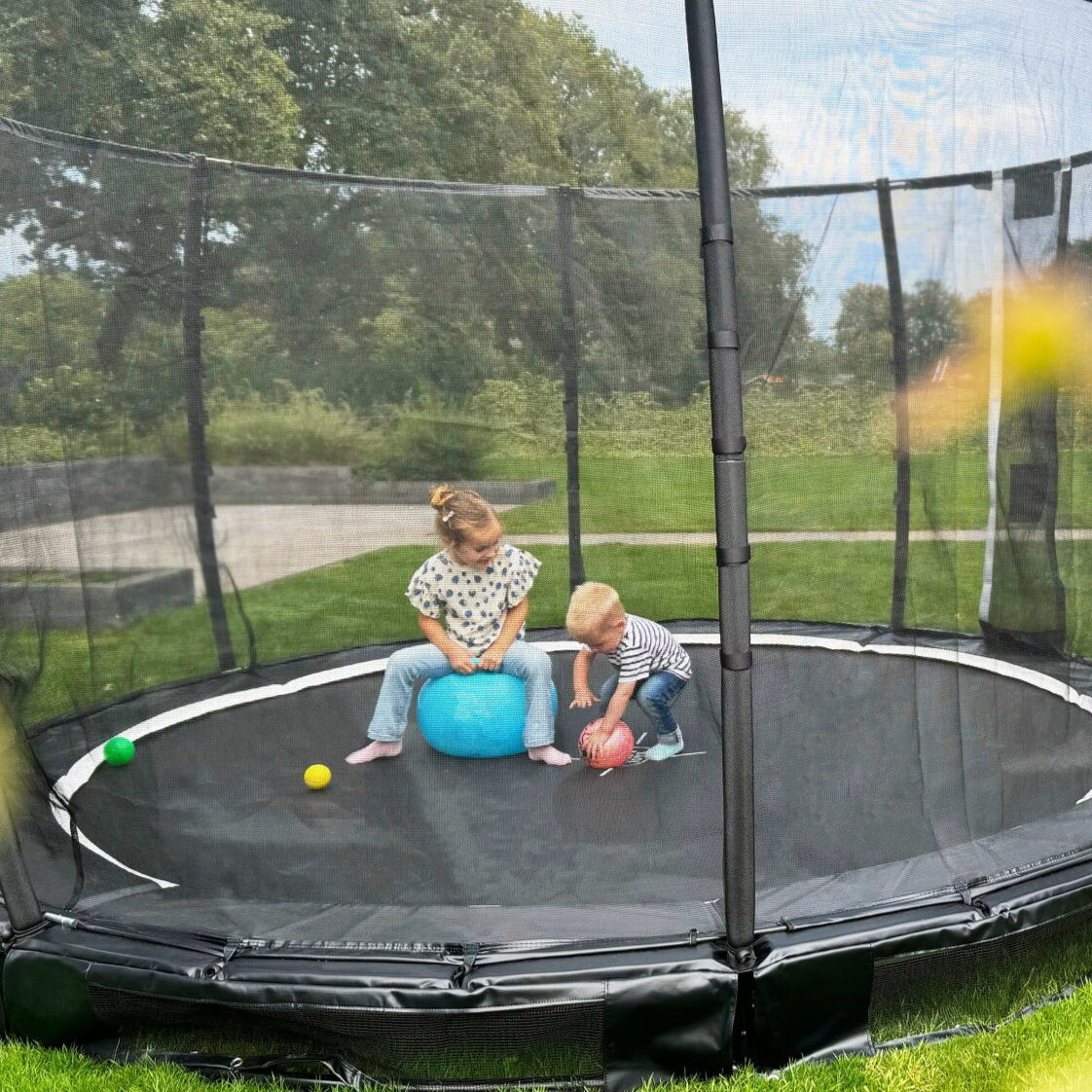 Exit Premium Ground Round Trampoline Black outside in the garden