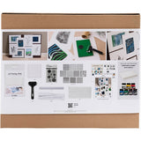 Cardboard box with a display of gel printing supplies and materials on a white background