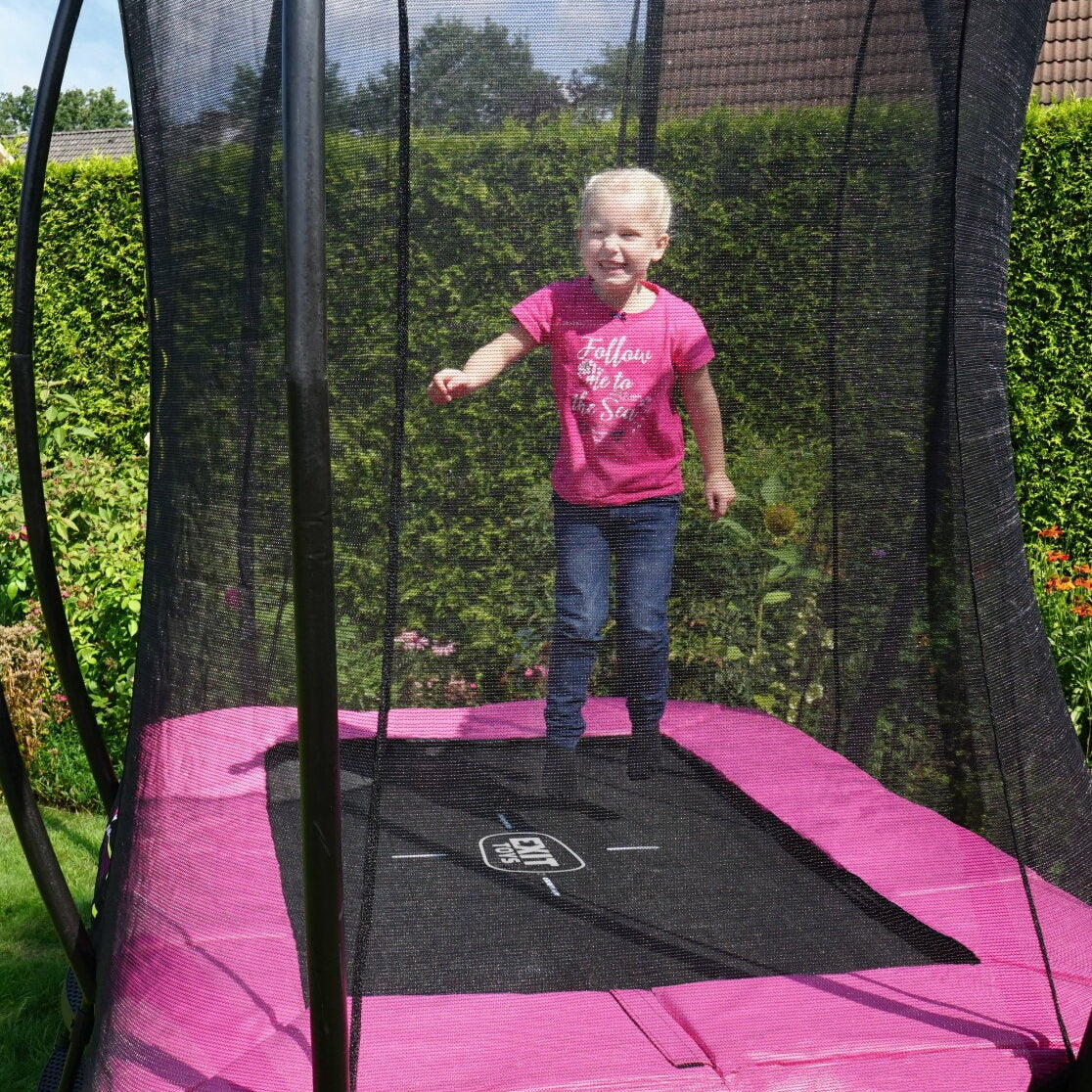 Girl jumping on a pink Exit Toys Rectangular Trampoline