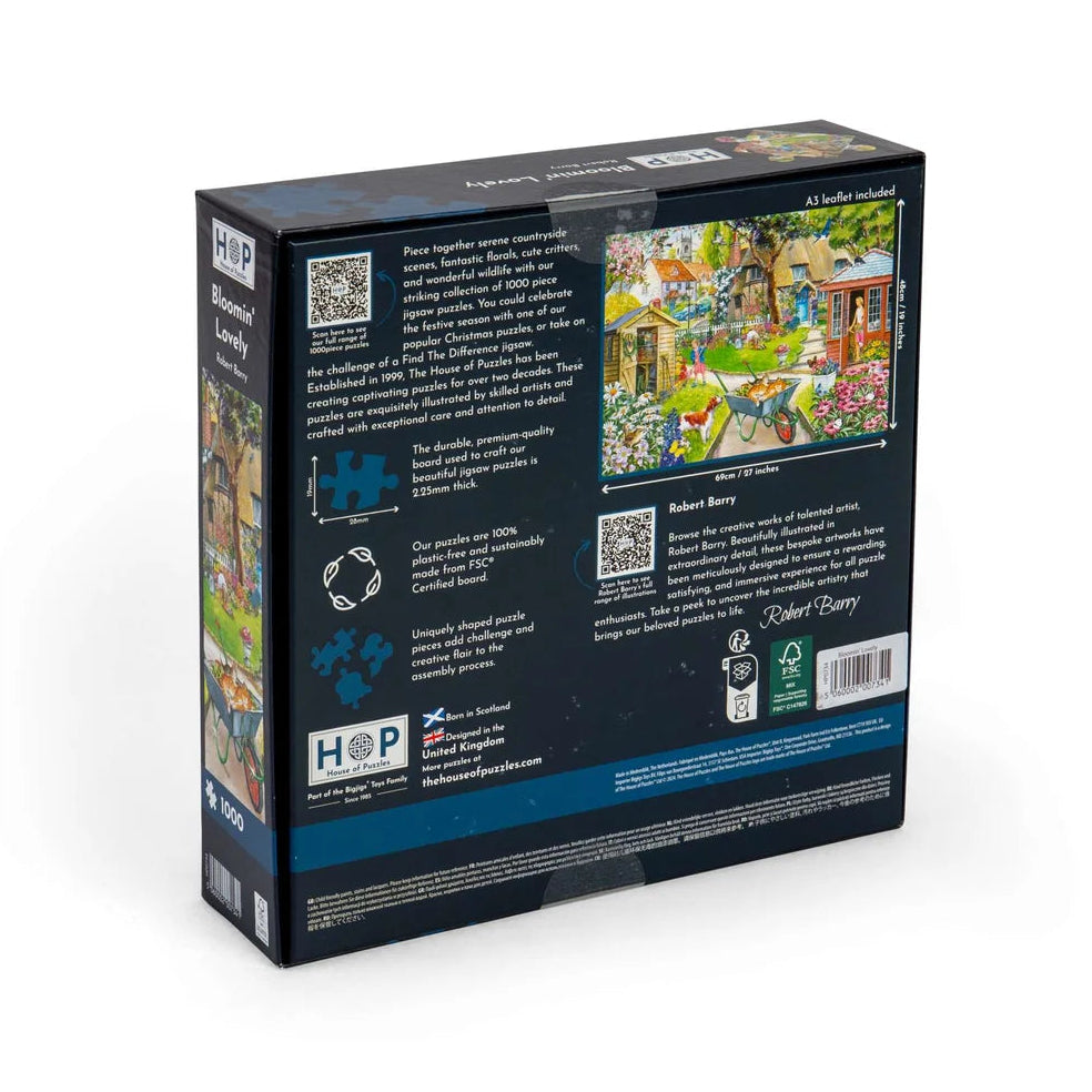 The back of a jigsaw puzzle box shown at a three-quarter angle on a clean white background. The box is dark blue with text, QR codes, recycling icons, and a colorful illustration of a garden scene.