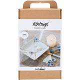 Kintsugi craft kit packaging with a candle and porcelain pieces on a white background