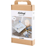 Kintsugi craft kit packaging with a white box and brown cardboard, featuring images of porcelain and tools.