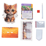 Collection of items including a cat-themed diamond painting kit, packaging, and tools on a white background.