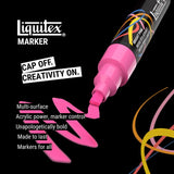 Liquitex marker with pink ink on a black background, featuring the brand name and product features.