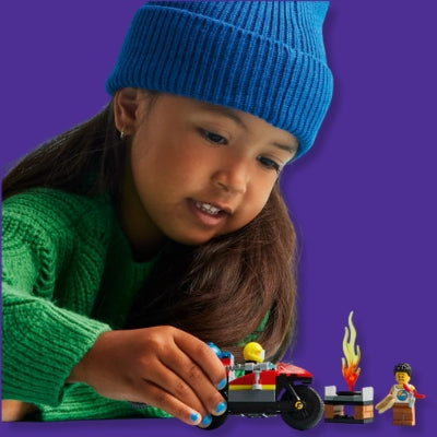 Child playing with LEGO toys on a purple background