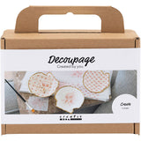 Decoupage kit packaging with decorative papers and tools on a white background