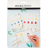 Mini creative kit with illustrations and a hand holding a craft item on a white background