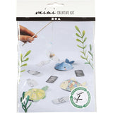 Mini creative kit packaging with sea-themed items and a hand holding a stick.