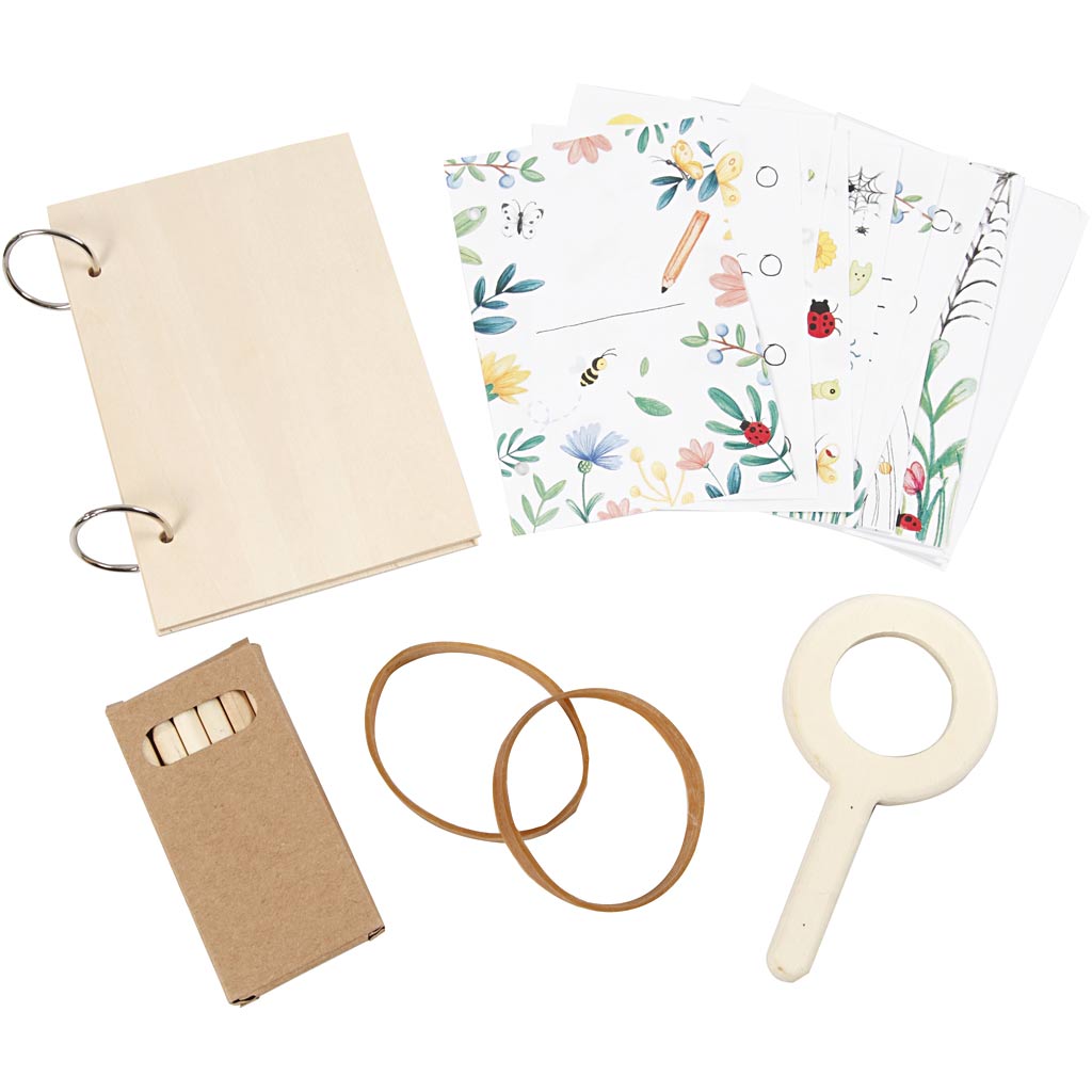 Set of stationery items including a notebook, stickers, rubber bands, and a magnifying glass on a white background.