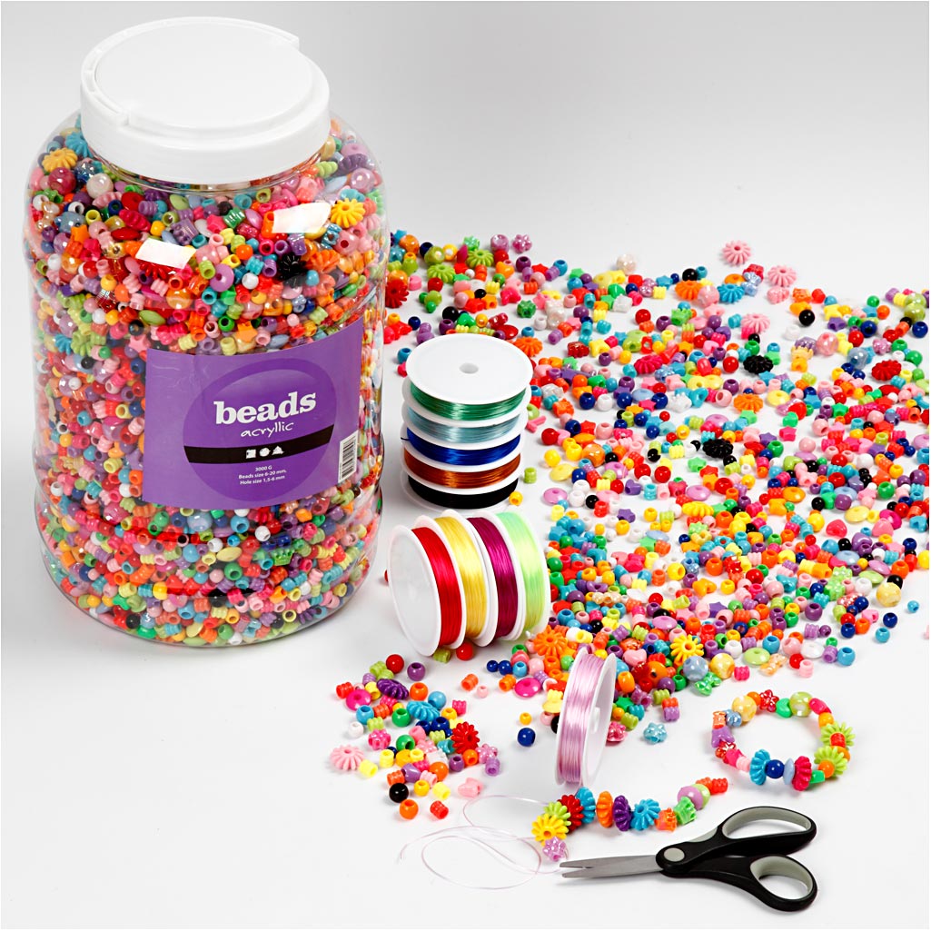 Colorful beads in a large container with spools of cord and scissors on a white background
