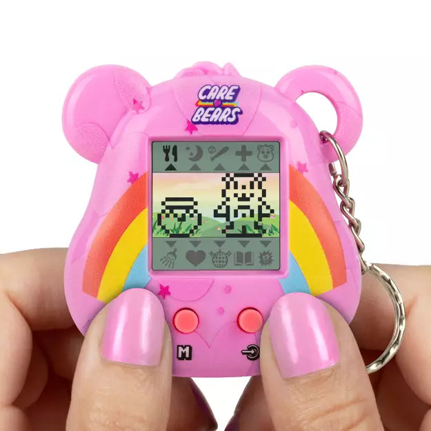 Pink Care Bears-themed digital toy held by a person with pink nail polish on a white background