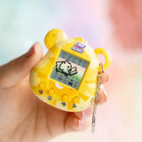 Yellow toy resembling a digital pet held in a hand with a blurred background