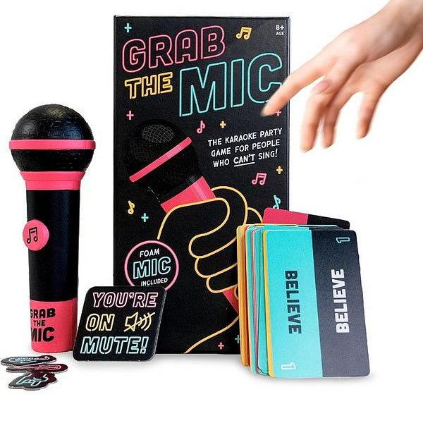 Grab the Mic karaoke party game set with a black and pink foam microphone, colorful cards, and a black instruction box, shown with a person's hand reaching toward it on a white background.