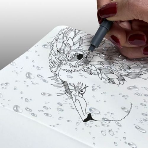 An artist's hand drawing a black outline of a lion with a fineliner pen by Zieler 