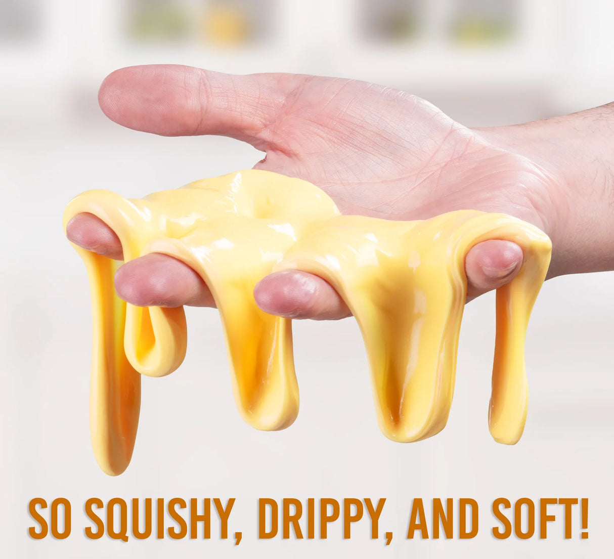 Hand holding yellow slime with text 'So squishy, drippy, and soft!' on a blurred background