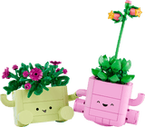 Two toy planters made from interlocking bricks, one yellow and one pink, with smiling faces on a transparent background.