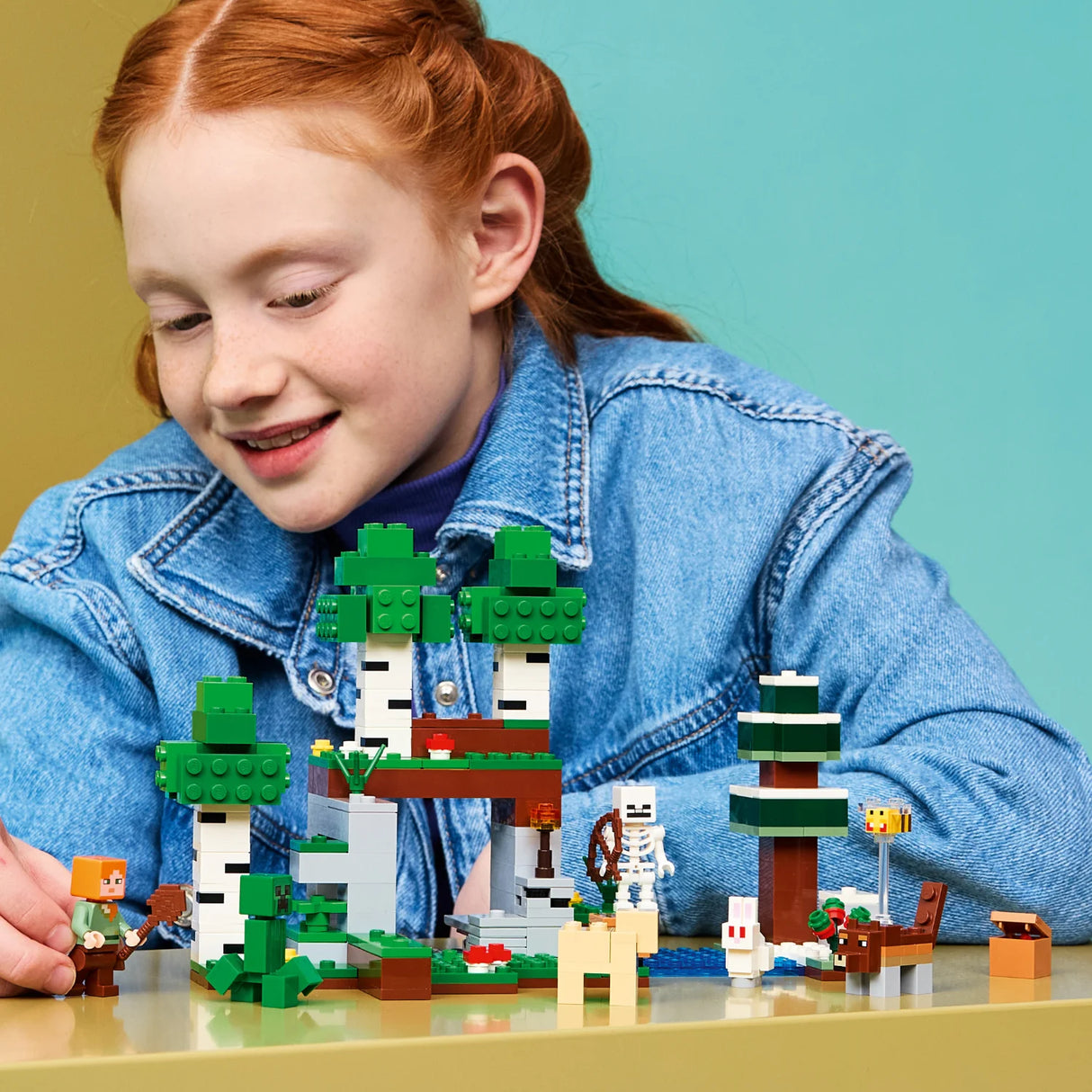 Child playing with a LEGO Minecraft set against a colorful background